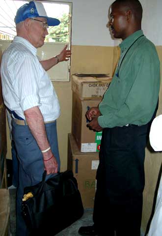 Dr. George Burgess discusses distribution of medical supplies with Luis Samacumbi of IECA in February, 2002.